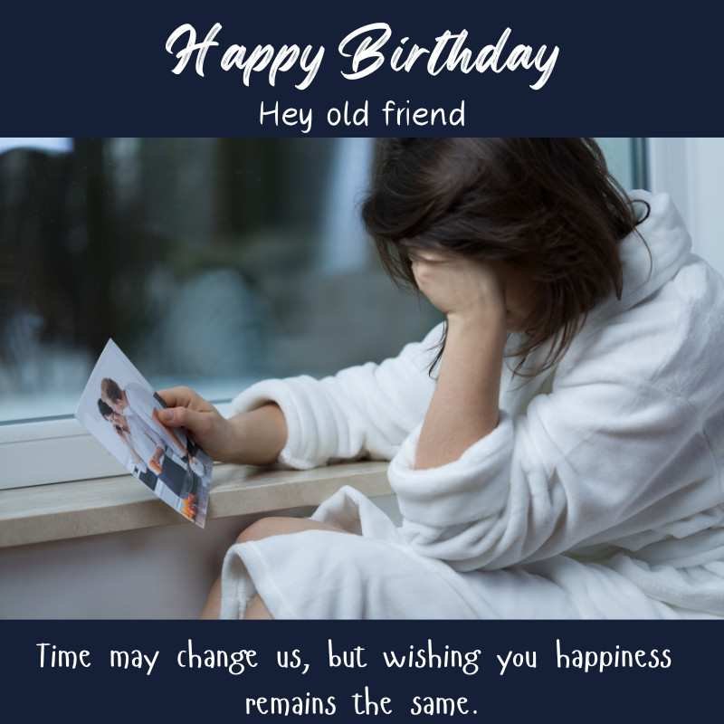 Sad woman holding a photo and sitting by the window with a nostalgic birthday message