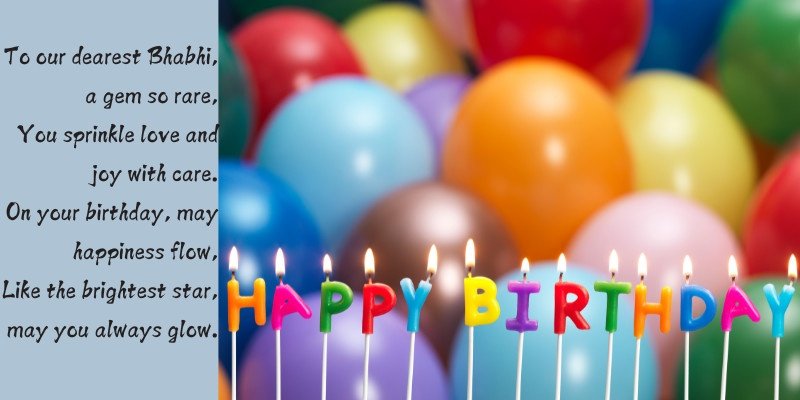 Colorful birthday balloons and lit candles spelling Happy Birthday