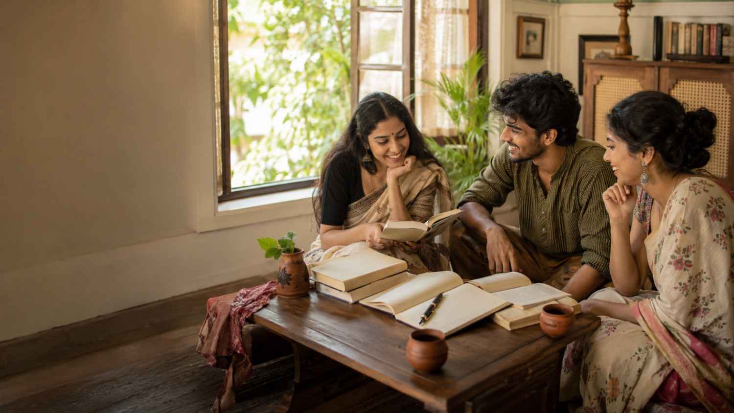 Funny poem in Bengali writing scene with an open notebook, books, tea and a playful cozy study setting by the window